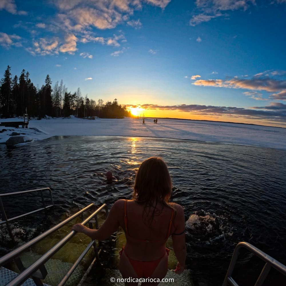 Cold exposure in frozen lake after Finnish sauna during the sunset