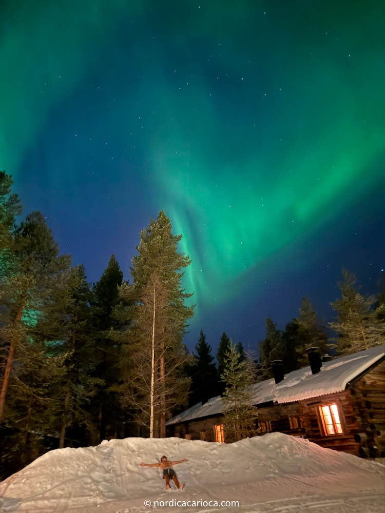 Northern lights next to cottage house in Lapland